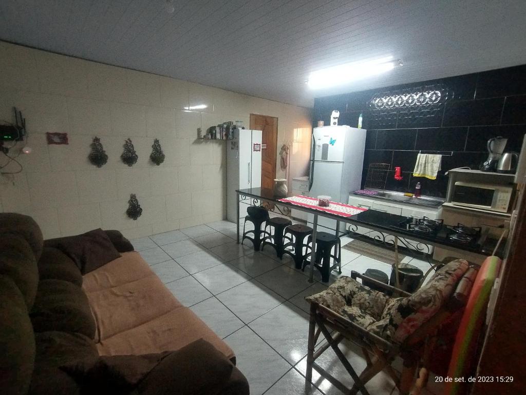 a living room with a couch and a kitchen at Tapera Florianópolis in Florianópolis