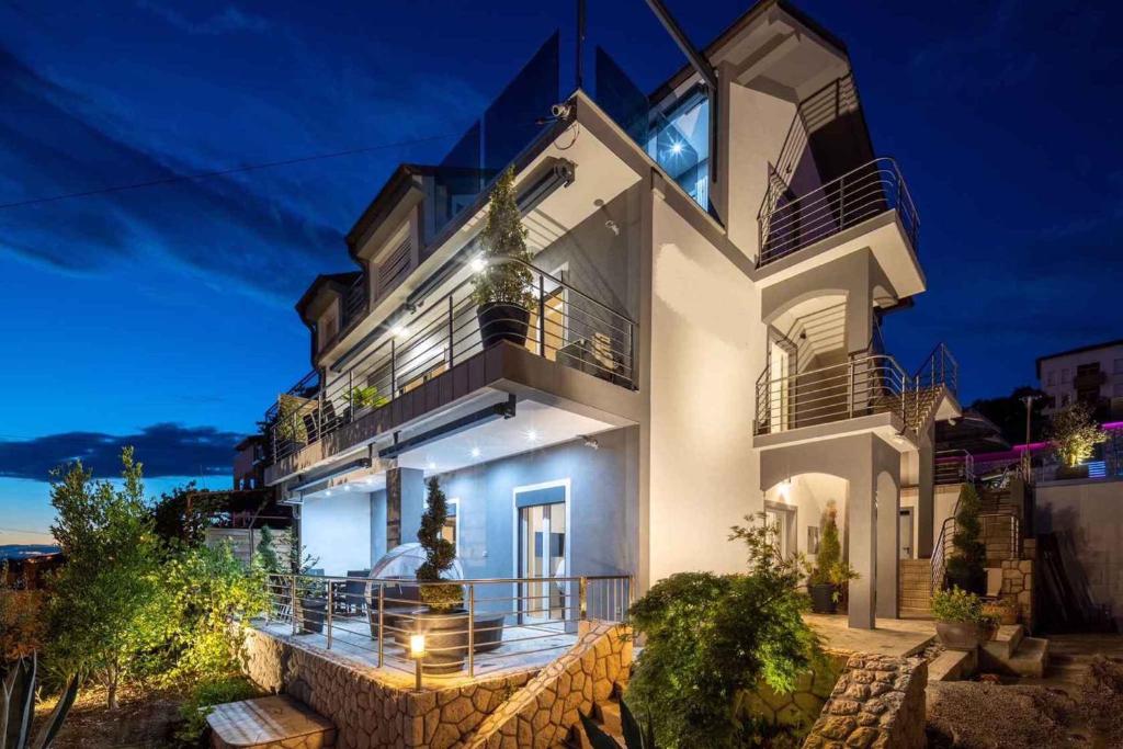 a large white building with a balcony at night at Crikvenica Apartment 9 in Crikvenica