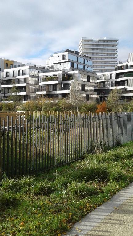 um edifício com uma cerca em frente a um edifício em Flat near Paris em Gennevilliers