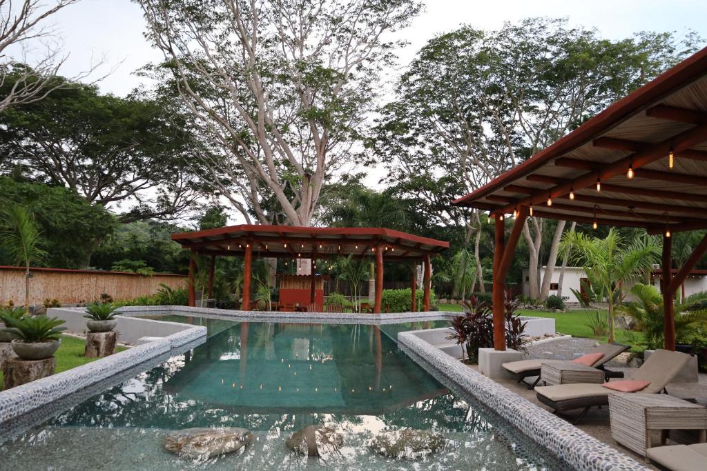 a swimming pool in a backyard with a gazebo at Solez Zihuatanejo in Zihuatanejo
