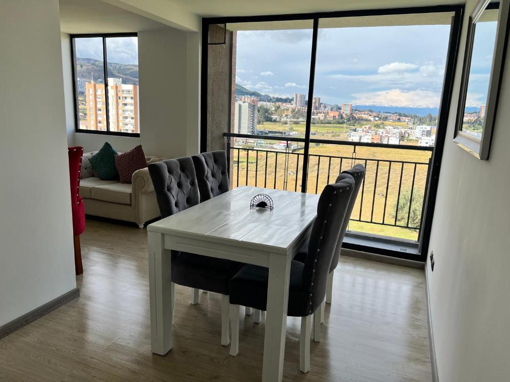 einen weißen Tisch und Stühle in einem Zimmer mit einem großen Fenster in der Unterkunft Nuevo Apartamento frente al Centro Comercial VIVA in Tunja