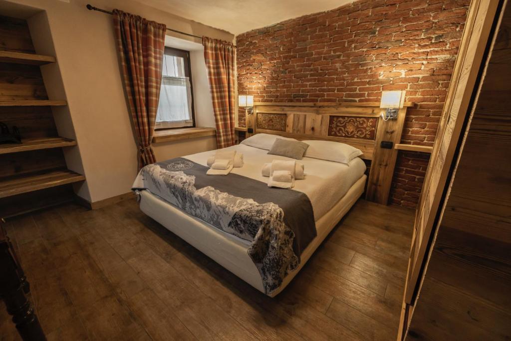 a bedroom with a bed and a brick wall at La Casa del cuore in Fenis