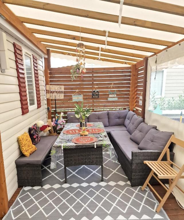 a patio with a couch and a table at Bungalow de 3 chambres avec piscine partagee et terrasse a Vias a 1 km de la plage in Vias