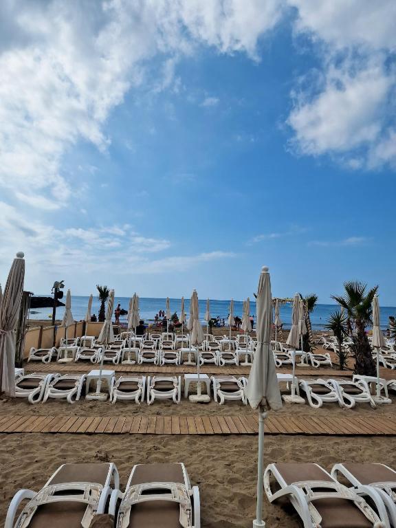 a group of chairs and umbrellas on a beach at Bungalow de 3 chambres avec piscine partagee et terrasse a Vias a 1 km de la plage in Vias