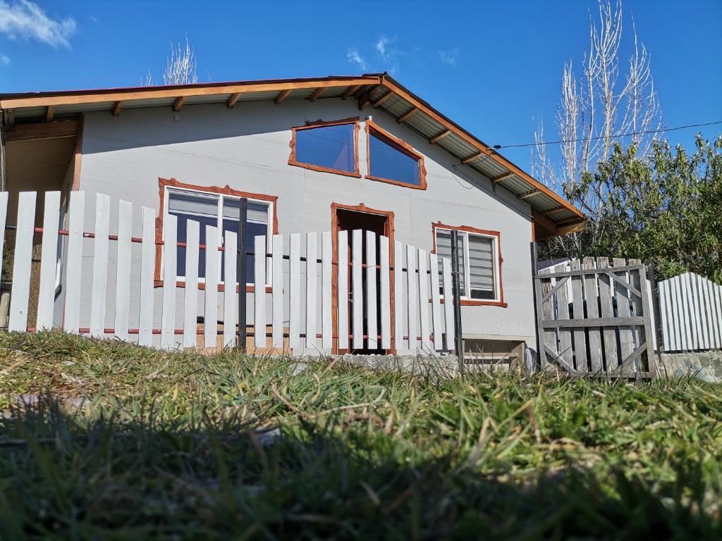 una casa blanca con una valla delante en Sol de la Patagonia Bahía Murta, en Bahía Murta