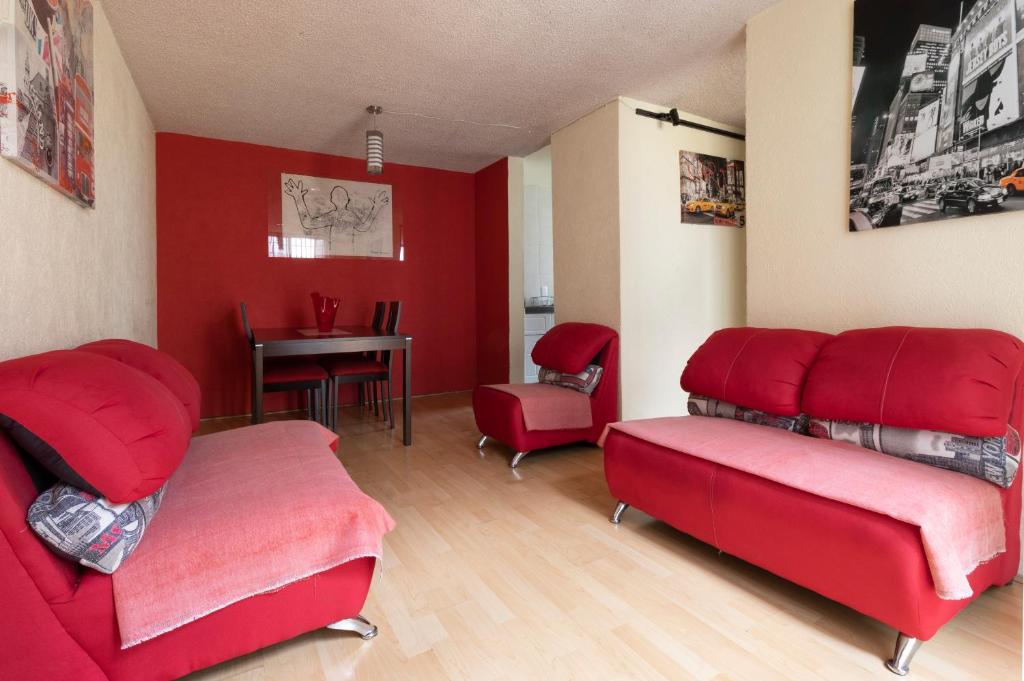 sala de estar con muebles de color rojo y mesa en Departamento ubicado en el centro histórico CDMX, en Ciudad de México