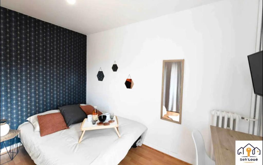 ein Wohnzimmer mit einem Sofa und einem Tisch in der Unterkunft Ch2 communs à partager Seh’Loué in Saint-Brieuc