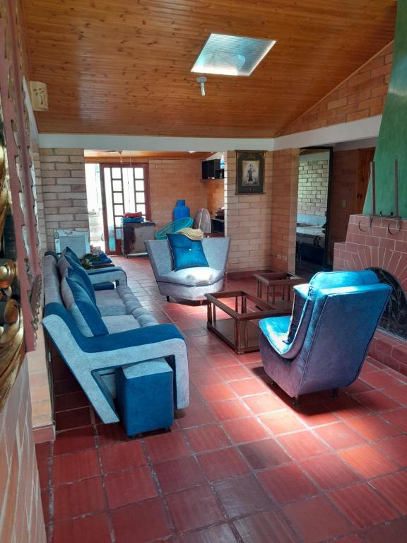 a room with couches and chairs on a patio at Villa pinzon in Paipa