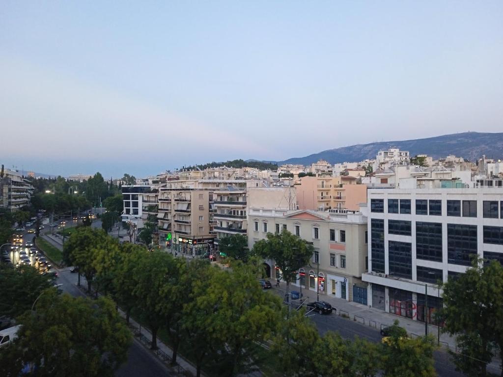 vistas a una ciudad con edificios y árboles en Acropolis studio with breathtaking city view en Atenas