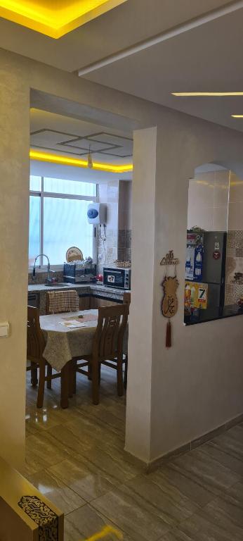 Résidence nahda في أغادير: مطبخ وغرفة طعام مع طاولة وكراسي