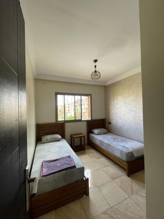 una camera con due letti e una finestra di Appartement en résidence privée a Marrakech