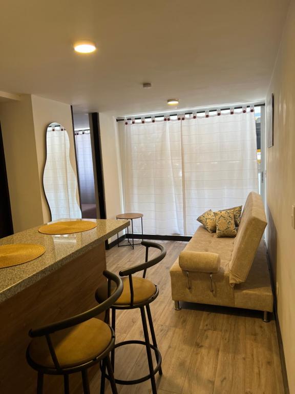 een woonkamer met een bank en een tafel en stoelen bij Apartamento Centro de Manizales in Manizales