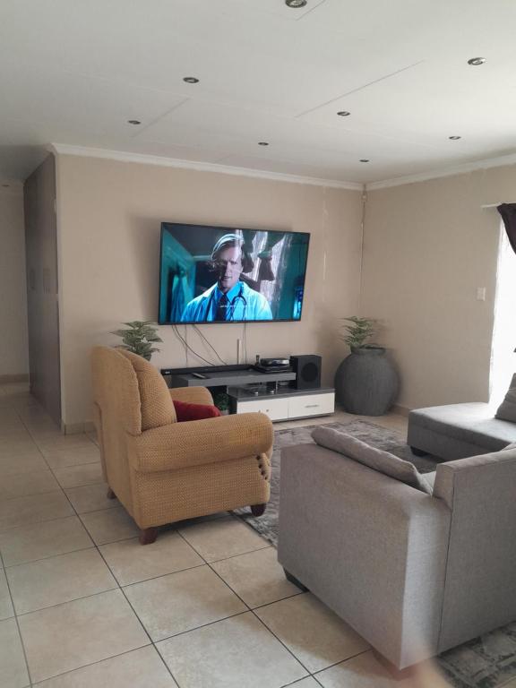 a living room with a couch and a tv at Secunda BackPackers in Secunda