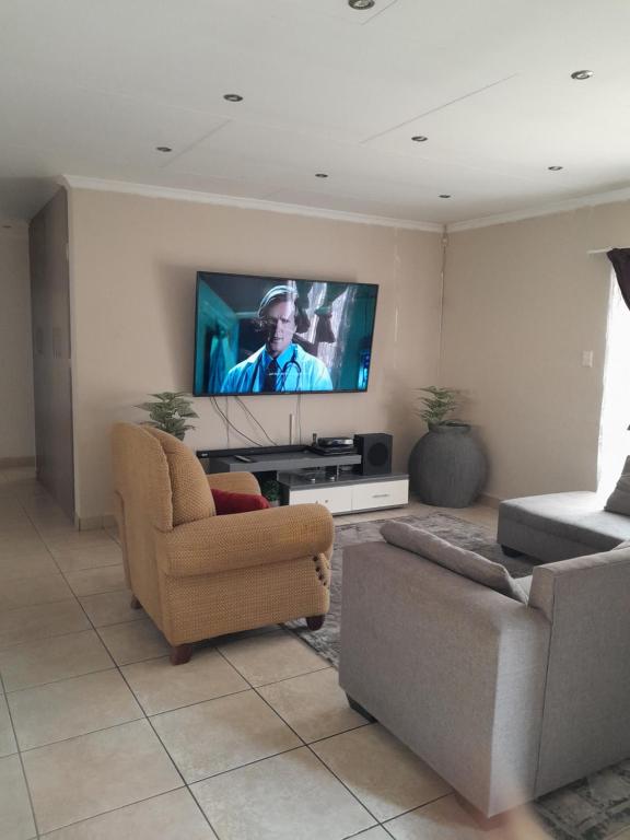uma sala de estar com um sofá e uma televisão em Secunda BackPackers em Secunda