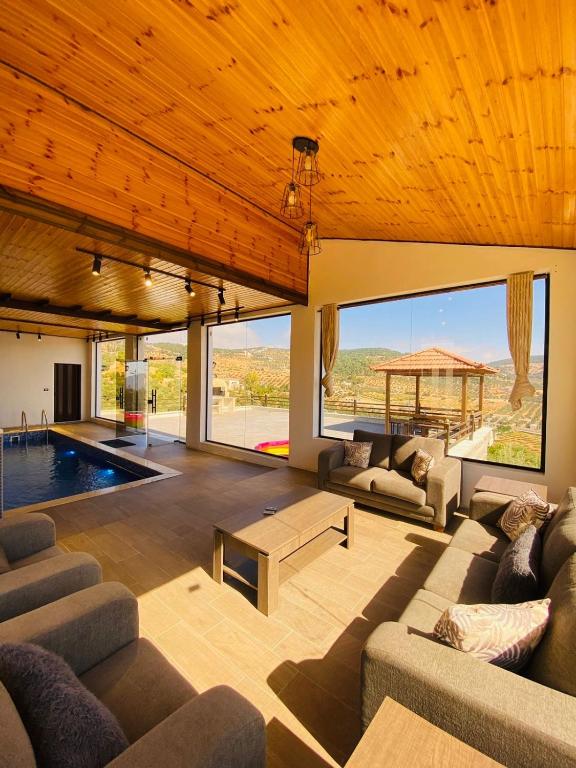 ein großes Wohnzimmer mit Sofas und einem Pool in der Unterkunft Souf view in Gerasa