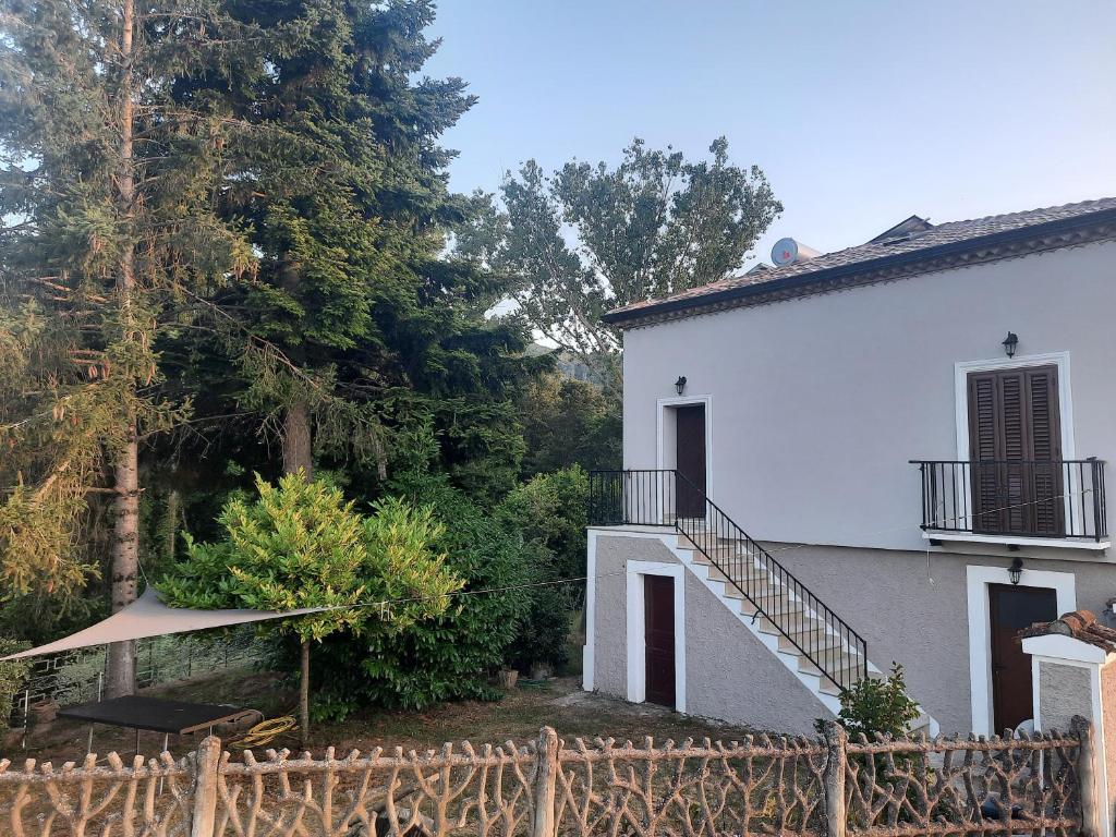 uma casa branca com uma cerca à frente. em La Casa del Mugnaio em Rotonda