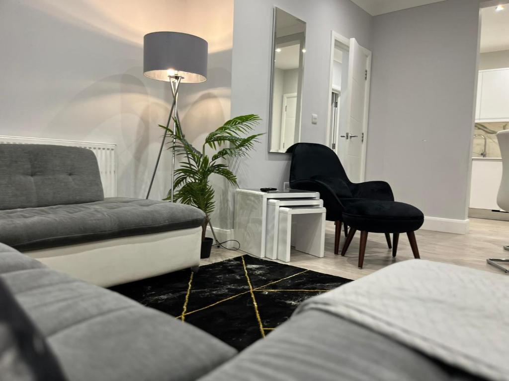 uma sala de estar com um sofá e uma cadeira em Modern & Spacious 2 bed Apartment at Addison Court - Sleeps 6, Free WIFI em Watford