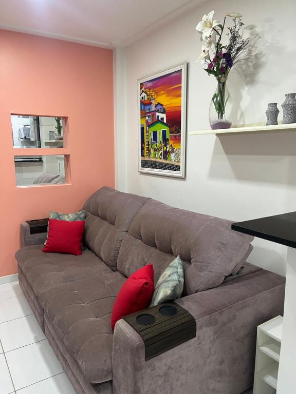 - un salon avec un canapé brun et des oreillers rouges dans l'établissement Fioravante's Apartment 2, à Rio de Janeiro