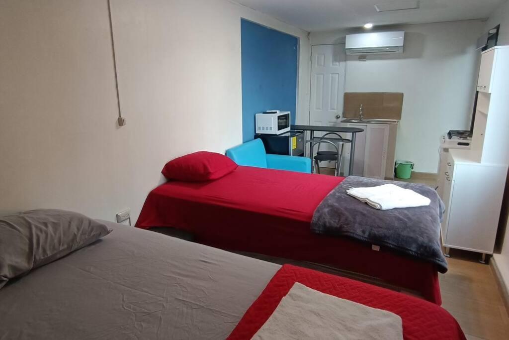 a room with two beds and a kitchen with a table at Suite Estudio 2 Buena Vista Santa Tecla in Nueva San Salvador