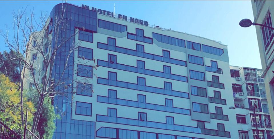wysoki biały budynek z mnóstwem okien w obiekcie HOTEL DU NORD w mieście Bidżaja