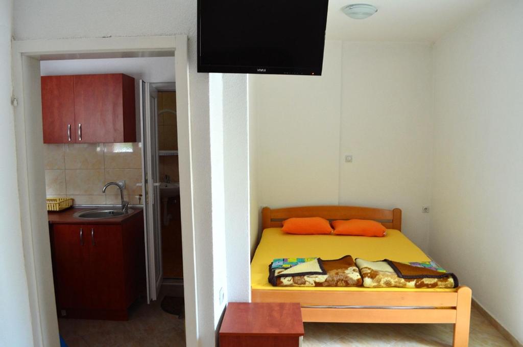 a small bedroom with a bed and a kitchen at Apartmani Tomar in Star Dojran