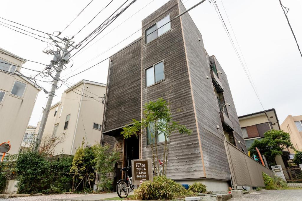 ein Haus mit einer Holzwand in der Unterkunft Plage Yuigahama in Kamakura