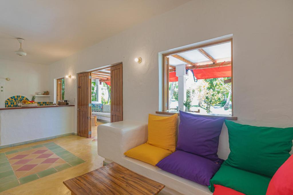 ein Wohnzimmer mit einem Sofa und bunten Kissen in der Unterkunft EVALUNA VILLAS LAS TERRENAS in Santa Bárbara de Samaná