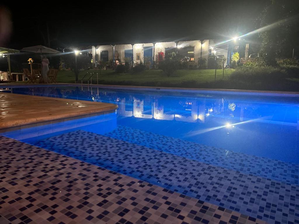 a swimming pool at night with lights in the background at Hacienda San Francisco in Venecia