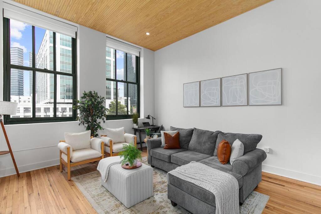 a living room with a couch and chairs and windows at NEW Downtown Modern Escape -The Lyric l King Bed l Gym l City View l Park FREE in Birmingham