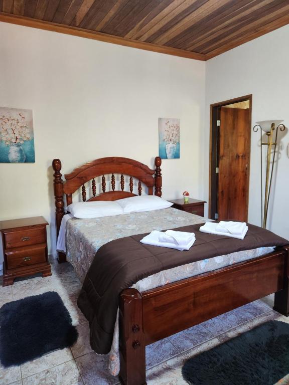 a bedroom with a bed with two towels on it at Pousada Pedacinho do Ceu - suite Anali 5 in Cunha