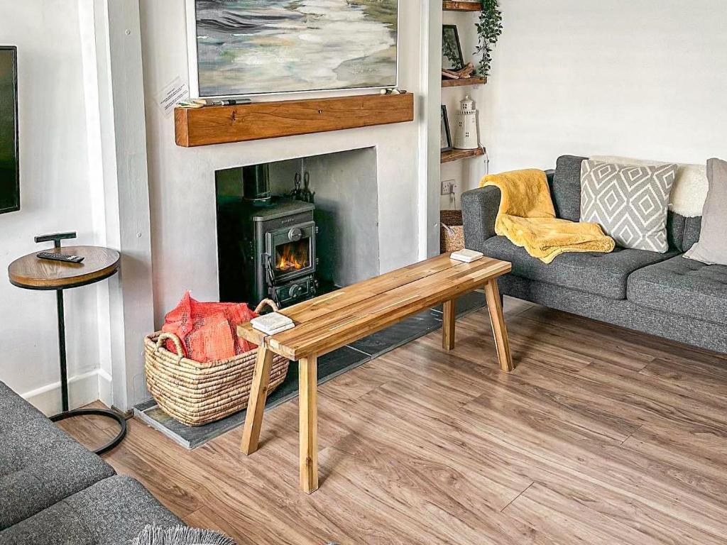 a living room with a couch and a fireplace at Seren Cottage By The Sea in Bodorgan