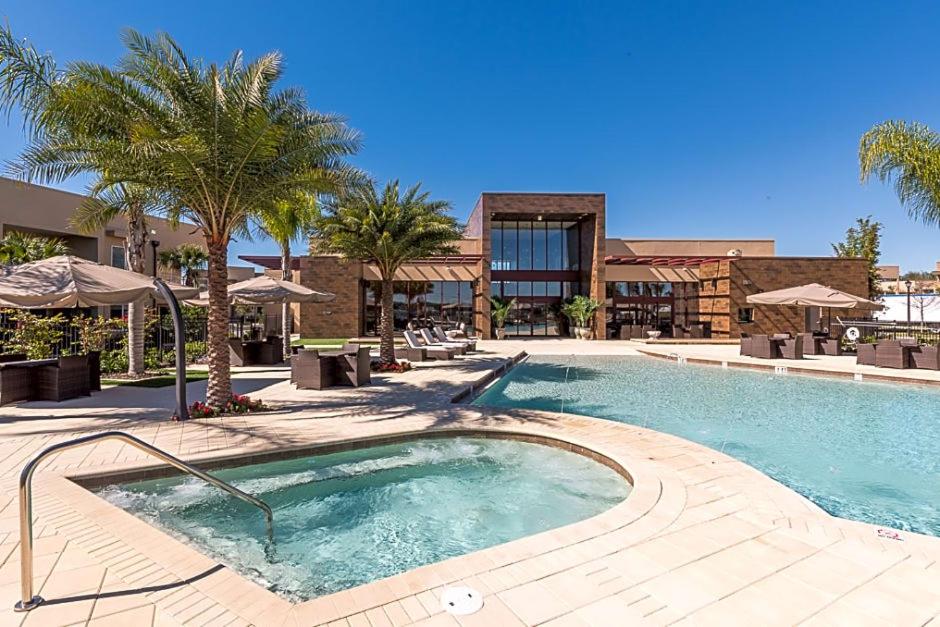 una piscina en un complejo con palmeras en GORGEOUS - Luxurious 4 bedroom House 10 min drive to Disney World en Orlando