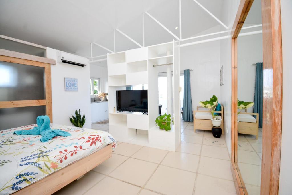 1 dormitorio con 1 cama y TV en una habitación en Babosam Apartments, en Boracay