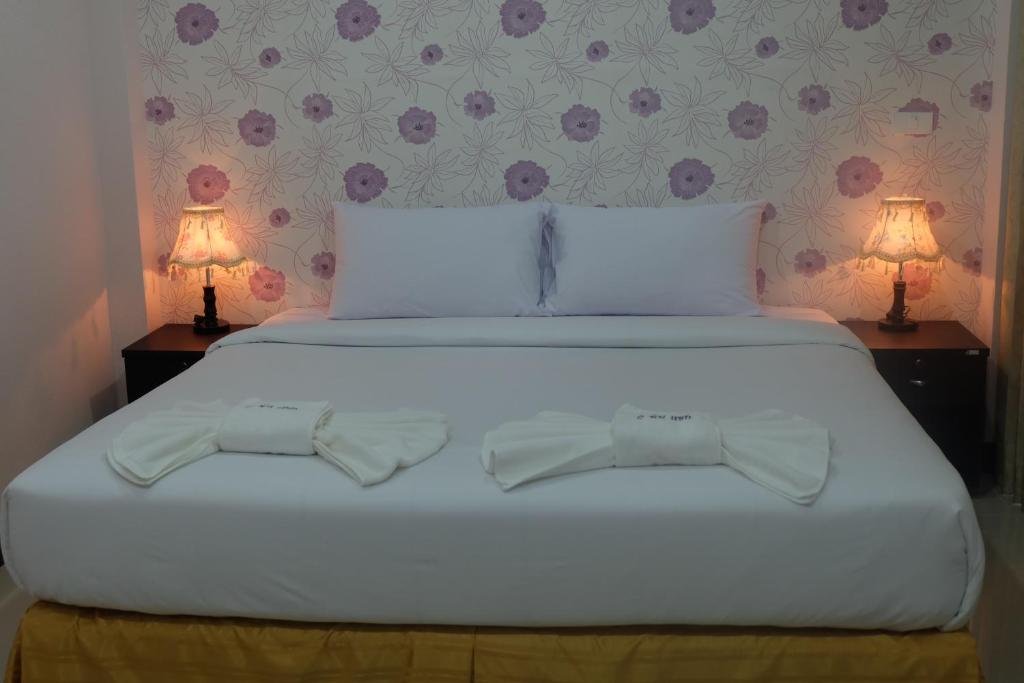 a bedroom with a white bed with two lamps at Tubkaek mansion in Tab Kaek Beach