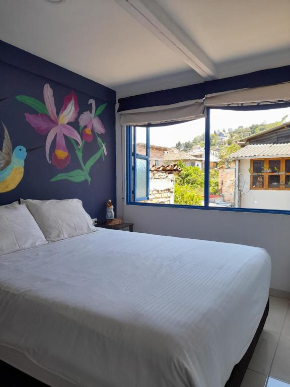 a bedroom with a white bed with a painting on the wall at Alojamiento Casa de T in San Agustín