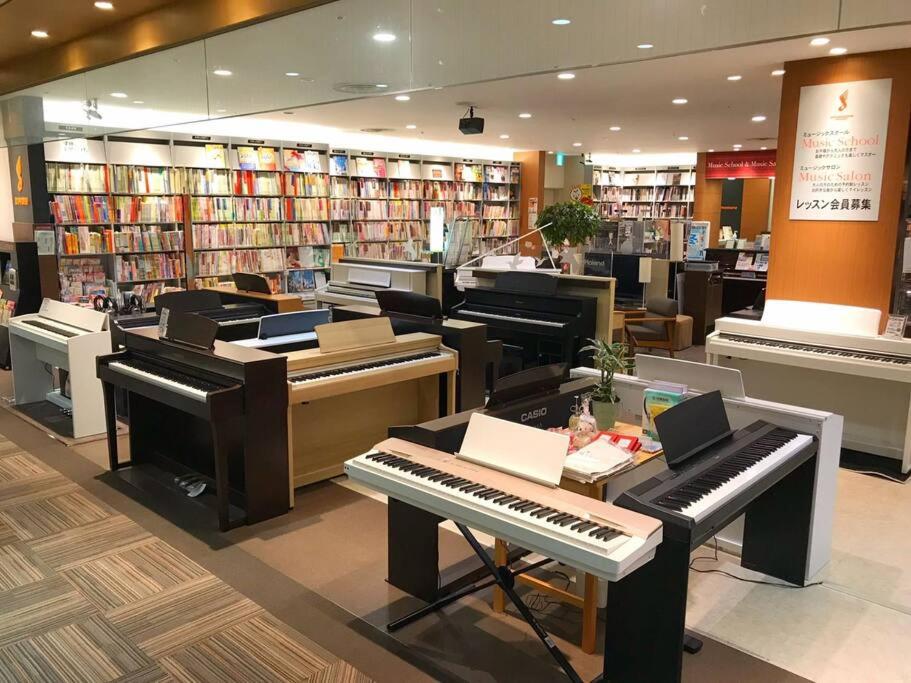市川市留连之家，隣東京的千葉県市川生活交通便利经济型旅馆、适合家庭游使用！可根据予约配置婴幼儿床及老人推椅。的中间有几架钢琴的图书馆