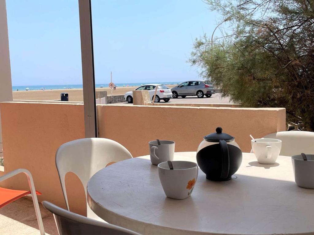 une table blanche avec un vase au-dessus dans l'établissement Appartement T2 en Bord de Mer avec Terrasse et Parking à Port-la-Nouvelle, 5 Couchages - FR-1-229C-89, à Port-la-Nouvelle