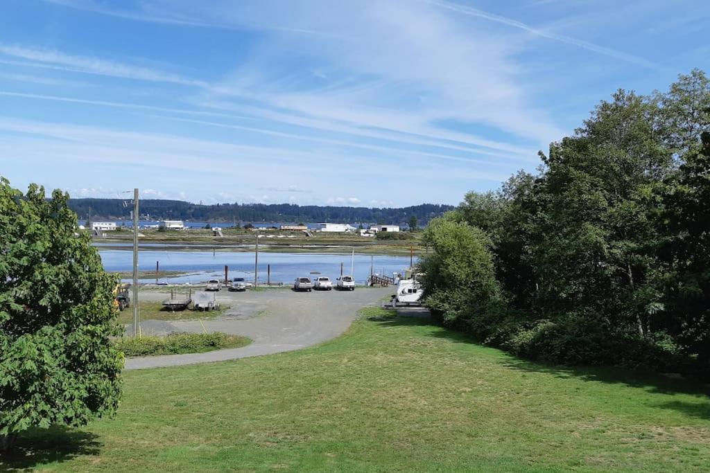 a parking lot with cars parked next to a body of water at Charming Hidden Gem- Ocean View and Marina in Campbell River