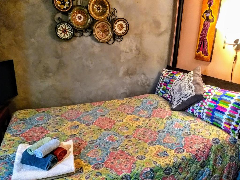 una camera da letto con un letto con piatti appesi al muro di Cozy ground floor rooms at the heart of Jackson Heights a Queens