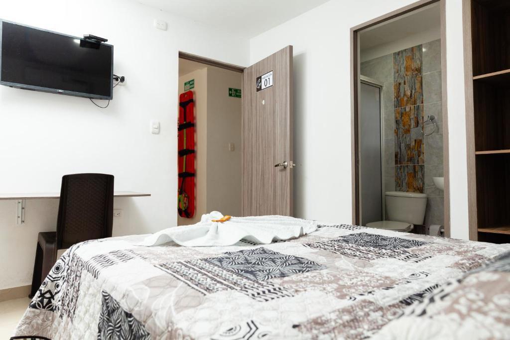 a bedroom with a bed and a tv on the wall at Hotel Galanni in Valledupar