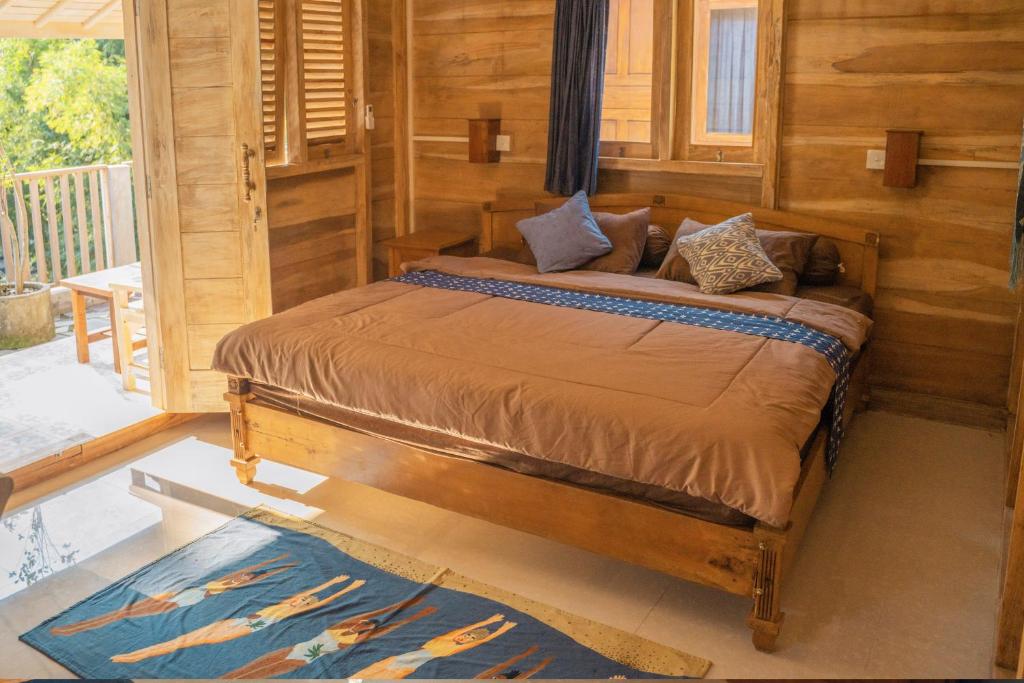 1 dormitorio con 1 cama en una habitación de madera en Secret Joglo Lebih, en Lebih