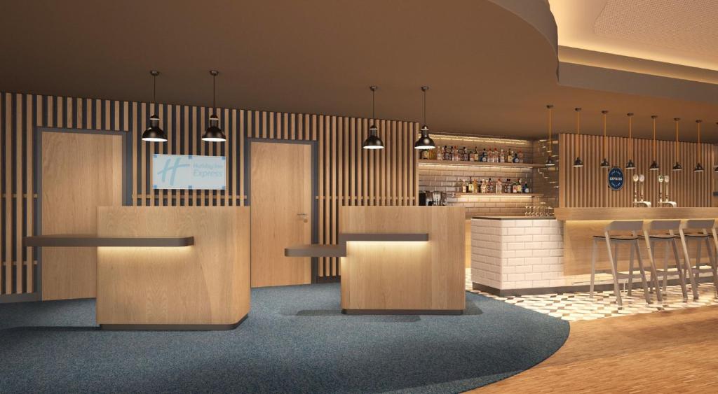 a restaurant with a bar with tables and stools at Holiday Inn Express - Remscheid in Remscheid