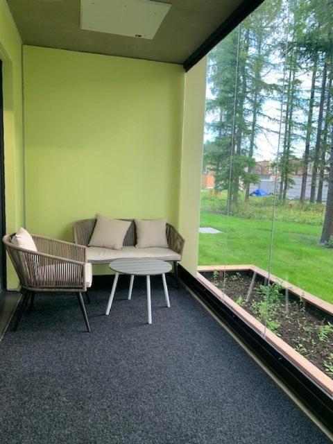 Zimmer mit Sofa, Tisch und Fenster in der Unterkunft Uusi kolmio in Oulu