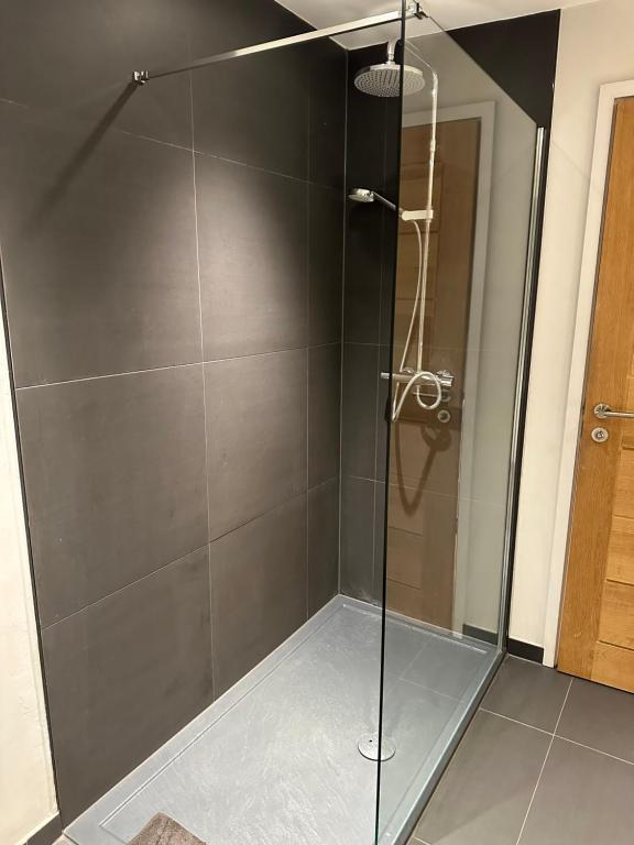 a shower with a glass door in a bathroom at Grendon Close Near to Gatwick Airport in Horley