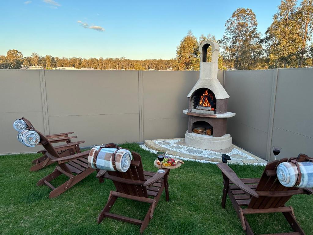 a backyard with two chairs and a fire pit at WineCountry Holiday House in Branxton
