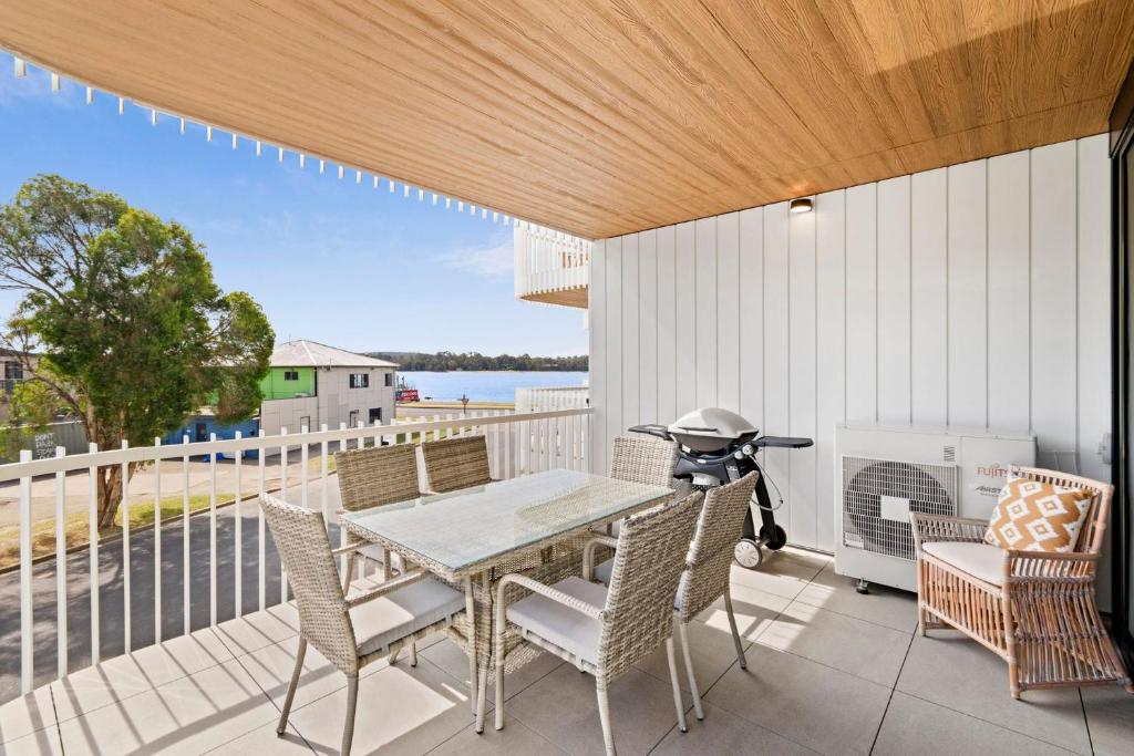 a patio with a table and chairs on a balcony at Ohana Apartments 103 in Batemans Bay
