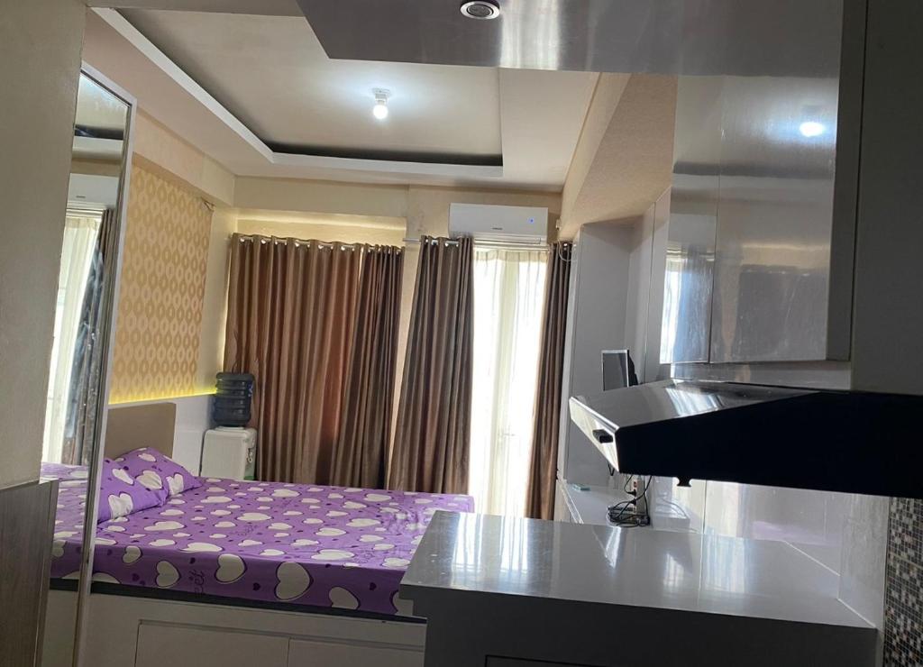 a kitchen with a purple bed in a room at Apartemen Malioboro city by Ameliarooms in Yogyakarta