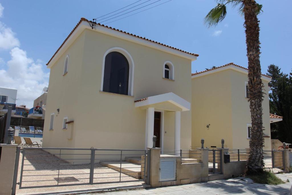 una pequeña iglesia blanca con una palmera en Villa Marina, en Pafos