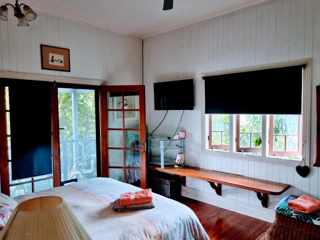 una camera con un letto e due grandi finestre di Homestay at Julie's a Cairns