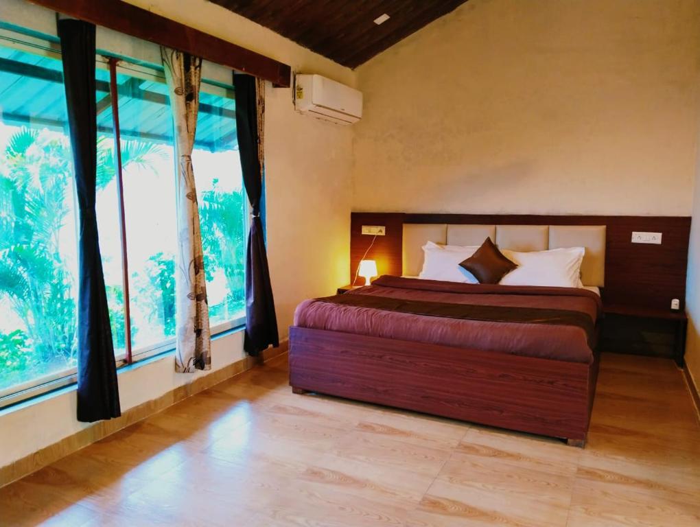 1 dormitorio con cama y ventana grande en Mysticstays Resort, en Wai